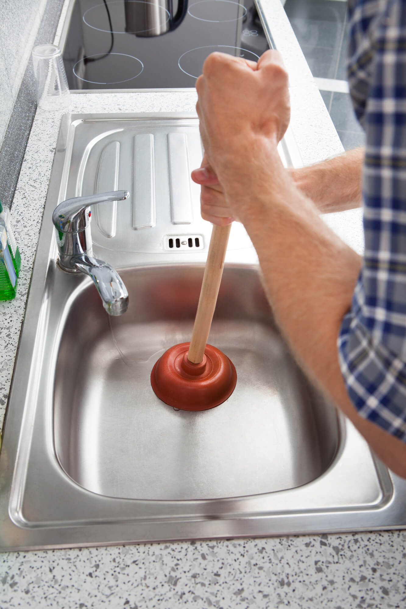 man using a plunger in a sink