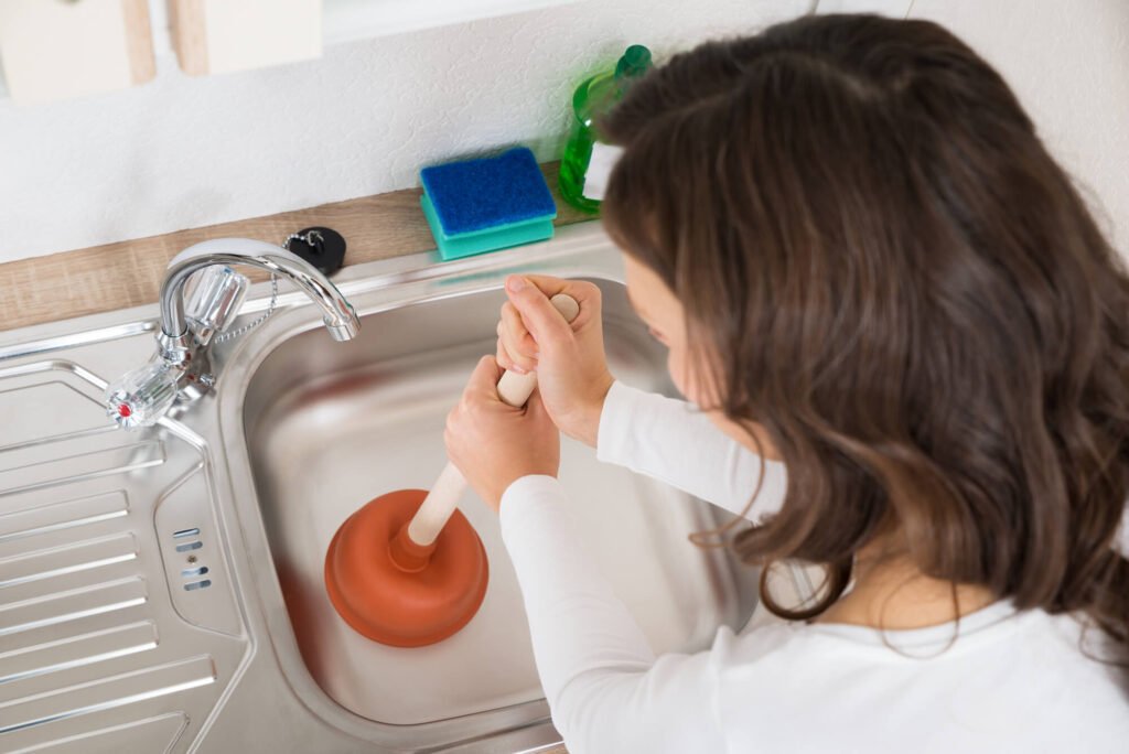 woman unblocking a drain