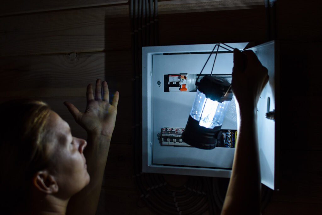 Power outage in house. A person with a lantern checks electrical panel.