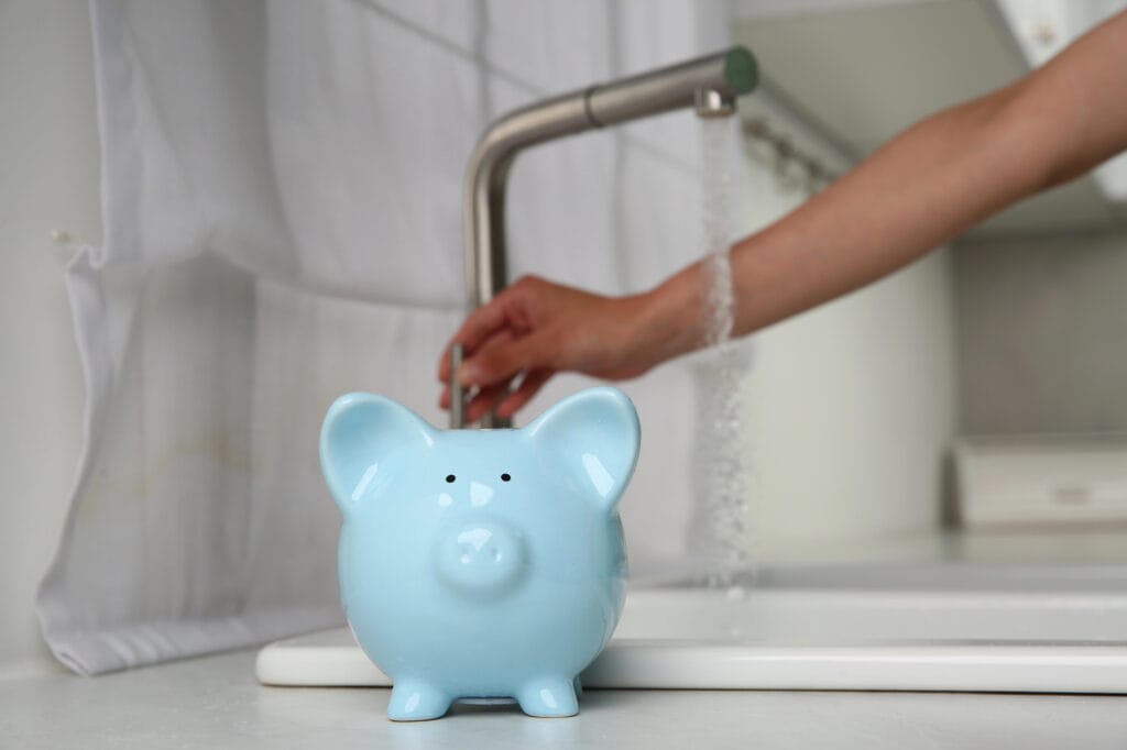 light blue piggy back with running faucet water at the background