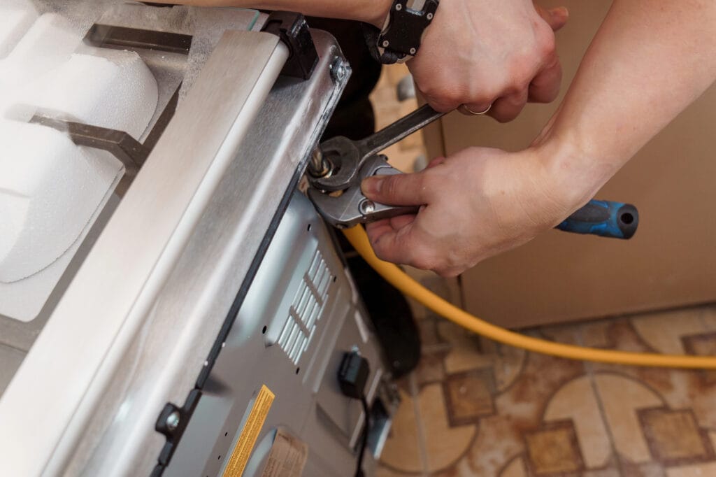 Professional Repair of a Gas Stove with Tools and Focused hands