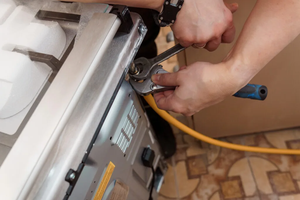 Professional Repair of a Gas Stove with Tools and Focused hands